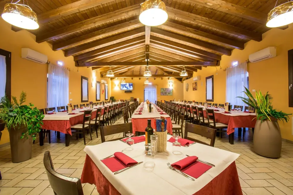 Ampia sala interna con soffitto a travi in legno, ideale per feste e cerimonie