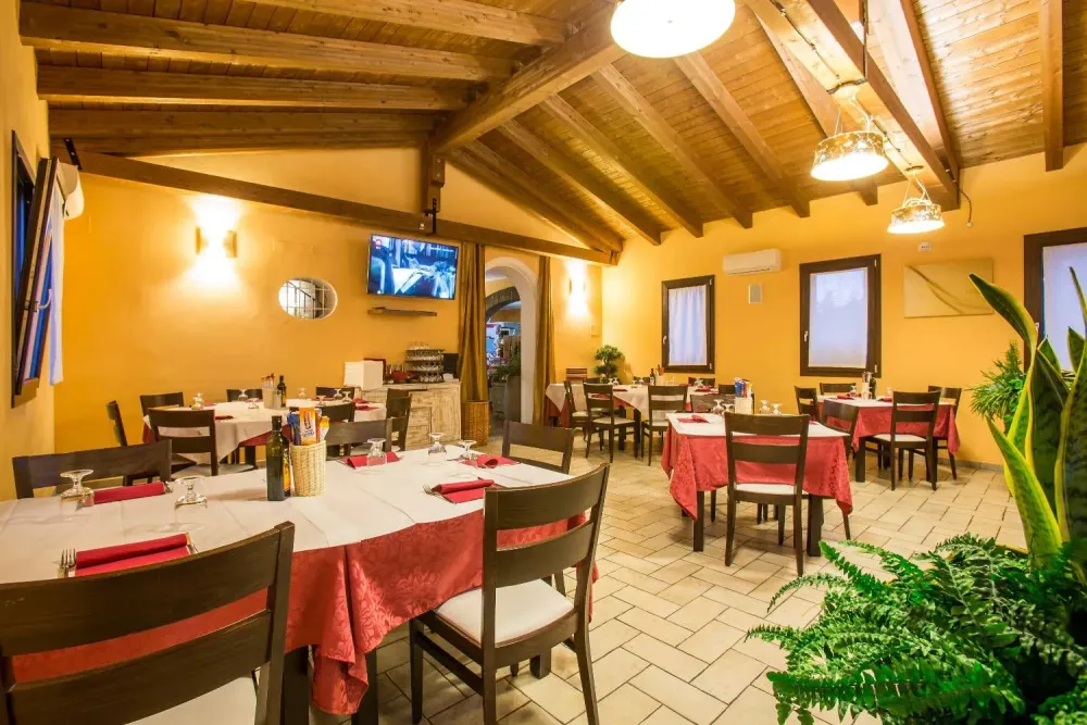 Sala da pranzo con tavoli apparecchiati e tetto a vista