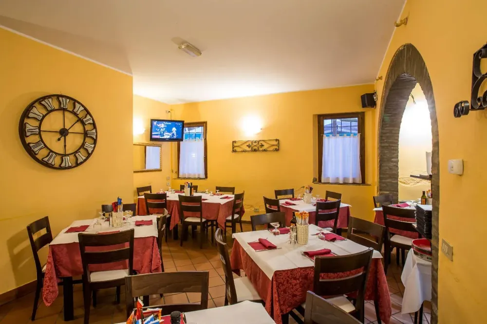Sala con arco in mattoni e tavoli pronti per il servizio