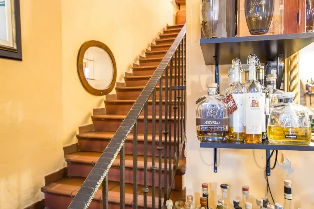 Scala interna e angolo bar con grappe e distillati